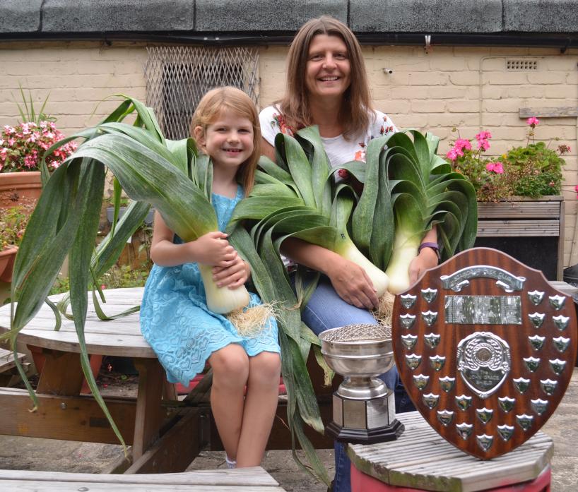 ALL SMILES: Louise Race and daughter Millie, 6, with the award winning entries to this year’s Staindrop Leek Club show TM pic
