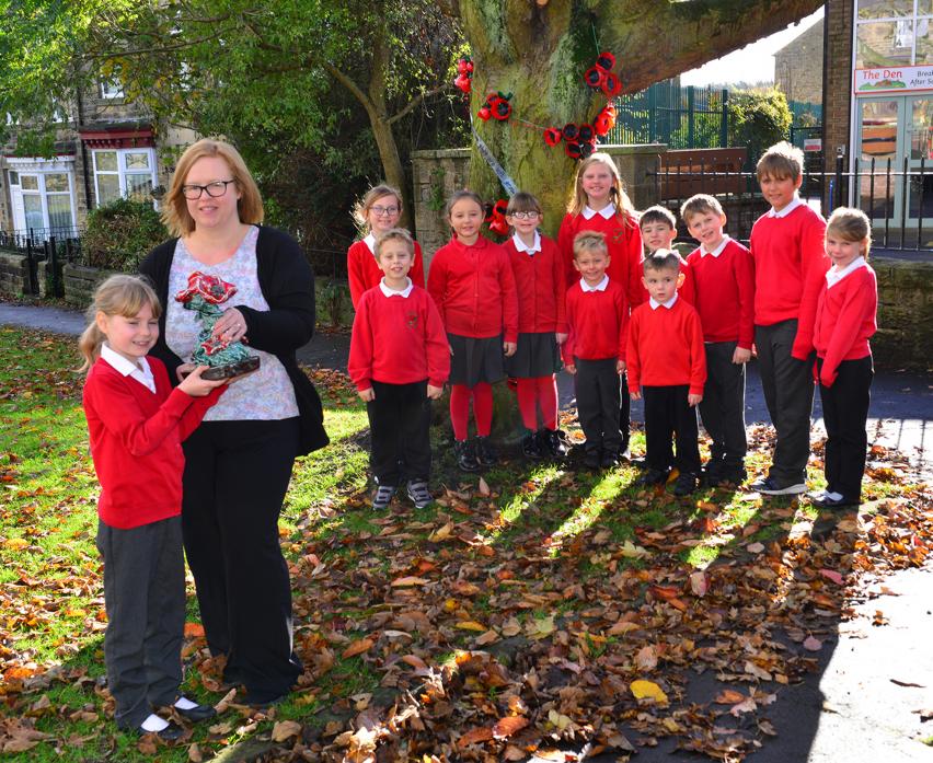 COMMEMORATION: Above, teacher Lyndsey Hargraves and pupil Isla Clen-Murphy with the ceramic poppy bouquet while other Cockfield Primary pupils show off the poppy display on the tree
