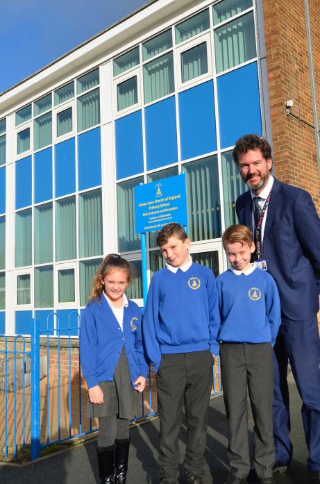 SCHOOL WORK: Headteacher Rob Goffee with Izzy Aspey, Joseph Waldock and Ollie Linsley, winners of a school writing competition, who unveiled the school’s new sign