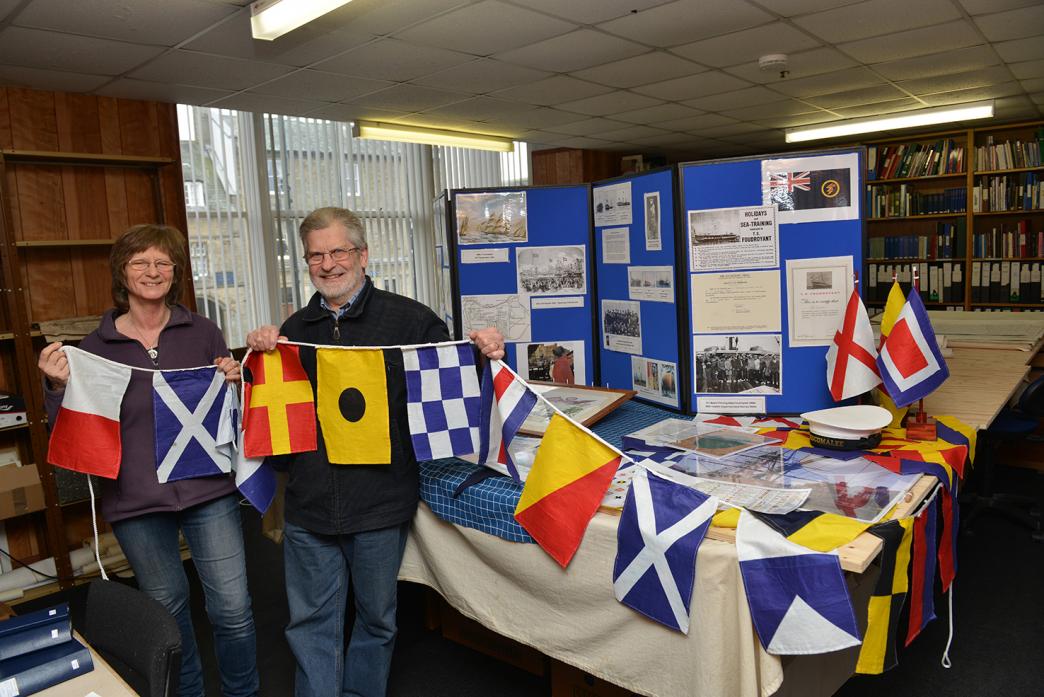 HISTORY EVENT: Cath Maddison and Derek Sims prepare the signal flags that form part of the HMS Trincomalee exhibition at The Fitzhugh Library.