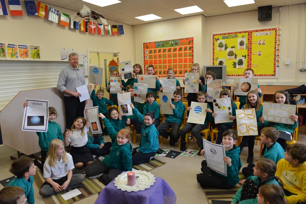 HAVING FUN: Head of science Chris Scaife looks on as children show off their space factsheets                        TM pic