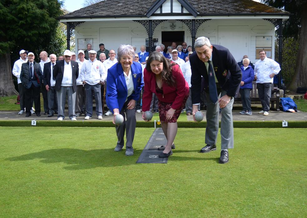 Val Cockfield, centre, plays the first bowl of the new season with president John Tallentire and ladies president Gillian Harle.