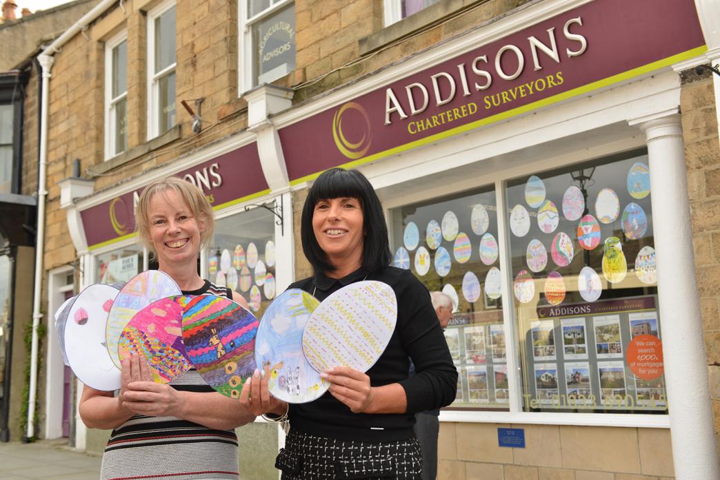 Melanie Wilson and Trudy Layton with some of the Easter egg artworks created by primary school children to brighten up their office window