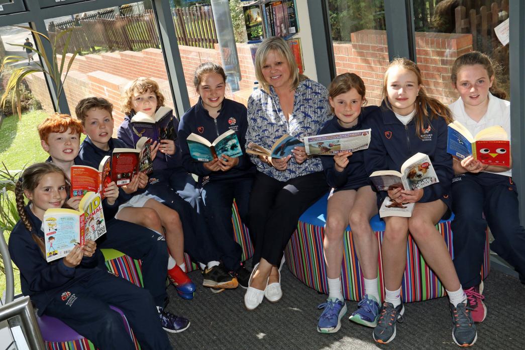 READ ALL ABOUT IT: Benjamin French, second left, with fellow pupils and teacher Rebecca Robertson in the year six reading area