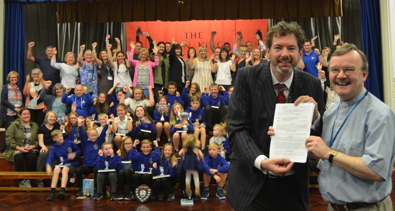 TOP MARKS: Headteacher Rob Goffee and Revd Alec Harding celebrate the “excellent” report with staff, parents and pupils at Green Lane Primary School