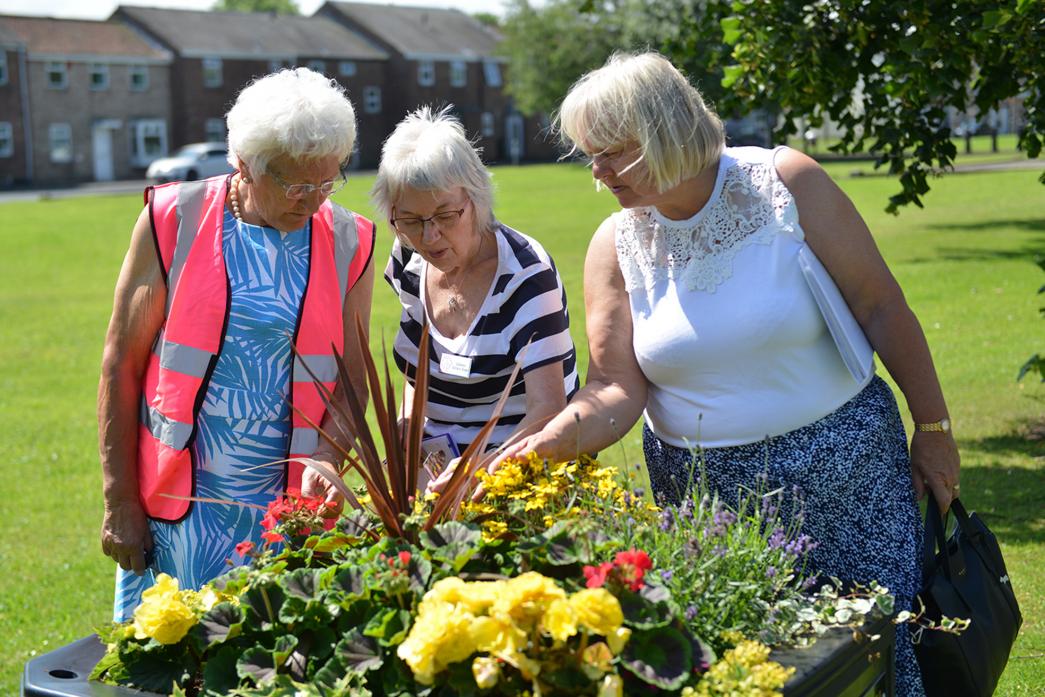 LOOKING GOOD: Northumbria-in-Bloom judge Colleen Ashwin-Kean is flanked by organisers Jean Pattison and Audrey Beck as she examines some of the planters in West Auckland