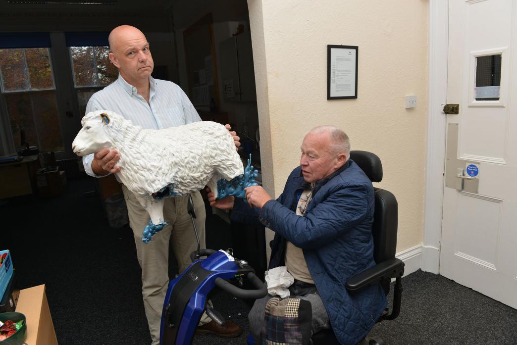MINDLESS: Town council clerk Michael King and deputy mayor Cllr Frank Harrison inspect the damaged sheep figure.