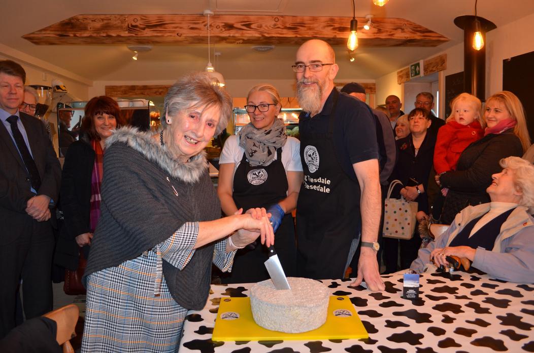 OPEN FOR BUSINESS: Grandma Doris cuts a special cake of Cheese at the opening of Cheesedale with Allison and Jonathan Raper and well-wishers