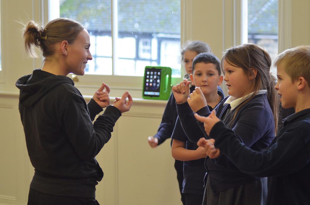 FINGER CLICKIN GOOD: Old Kent Road's Adele Joel shows Middleton pupils how to click their fingers. Right, Hope McAdam gets into the swing of things
