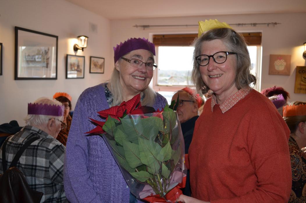 SAY IT WITH FLOWERS: Joan Whiteley (pictured with volunteer Sally Davies) was thanked for the Christmas treat at the Games for the Brain session