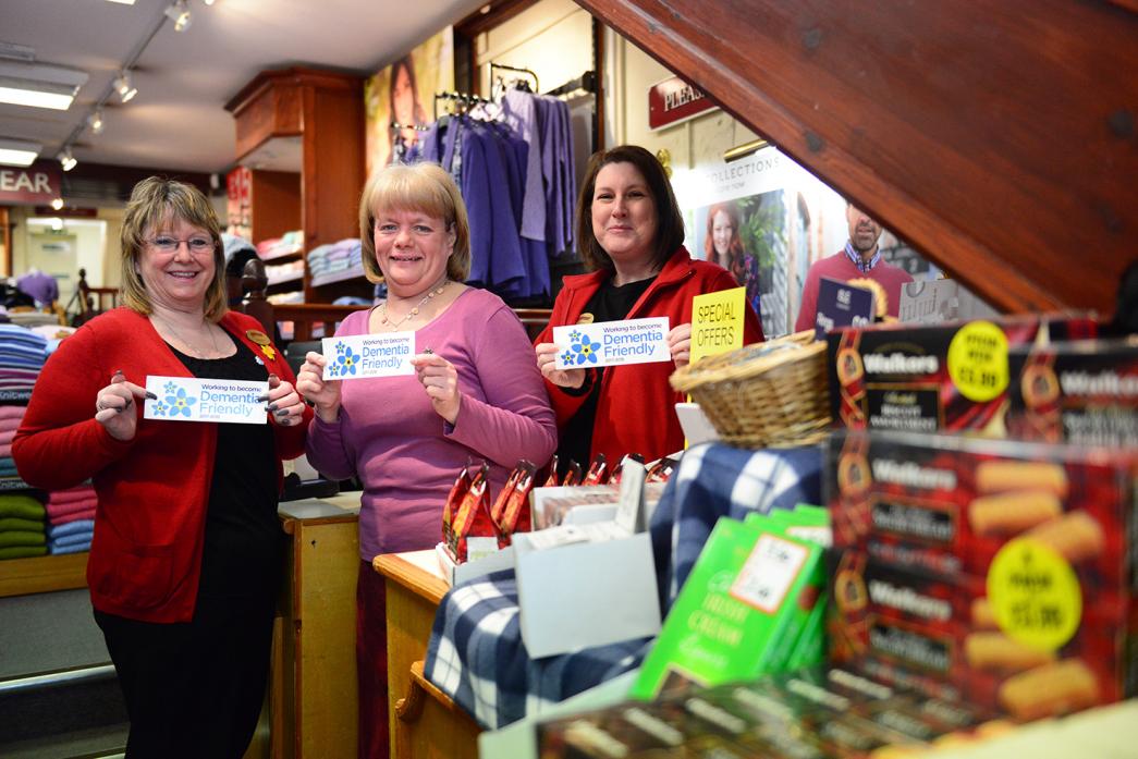 FIRM FRIENDS: Michelle Reed and Andrea Gipps, of Edinburgh Woollen Mill, with former  dementia advisor Nicky Tullock display the signs that will go up in the shop window