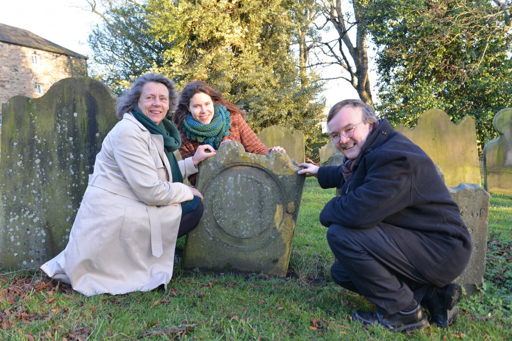 UNUSUAL HERITAGE: Curate Revd Sarah Cliff, DigVentures’ Johanna Ungemach and Revd Canon Alex Harding investigate a cheese press stone that has been recycled as a gravestone at St Mary’s Church, in Barnard Castle 						             TM pic