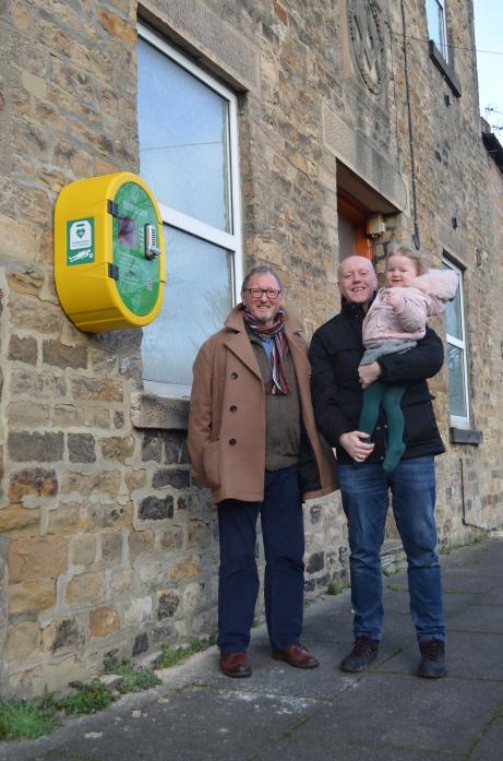LIFE SAVER: Freemason and Rose of Raby secretary, Morris Race, with Phil Cox and two-year-old daughter Marthaat the defibrillator installed in memory of freemason Dave Cox