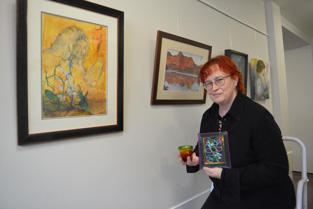 ON DISPLAY: Wendy Blair shows off some of her glass painting artwork alongside the works of Staindrop artist Graham Willis. They feature in the exhibition at The Bistro, in Scarth Memorial Hall 									             TM pic