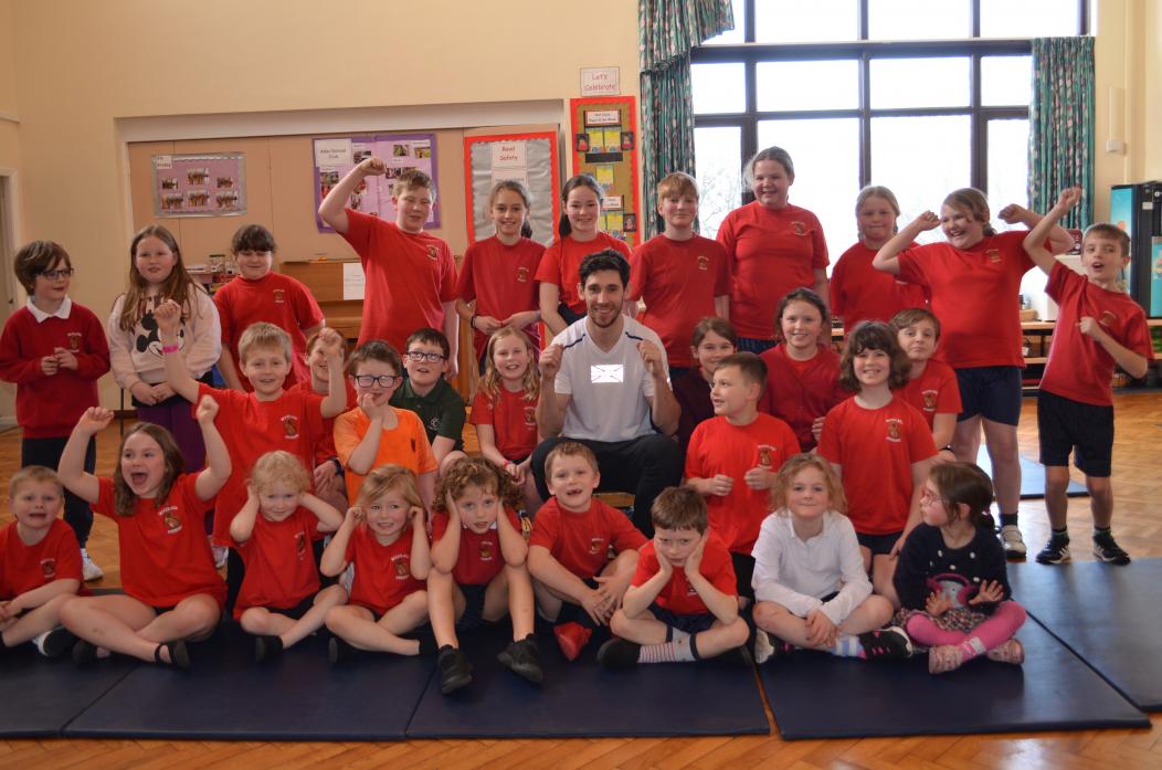 THREE CHEERS: Pupils from Woodland School with British high-jumper David Smith  						                                 TM pic