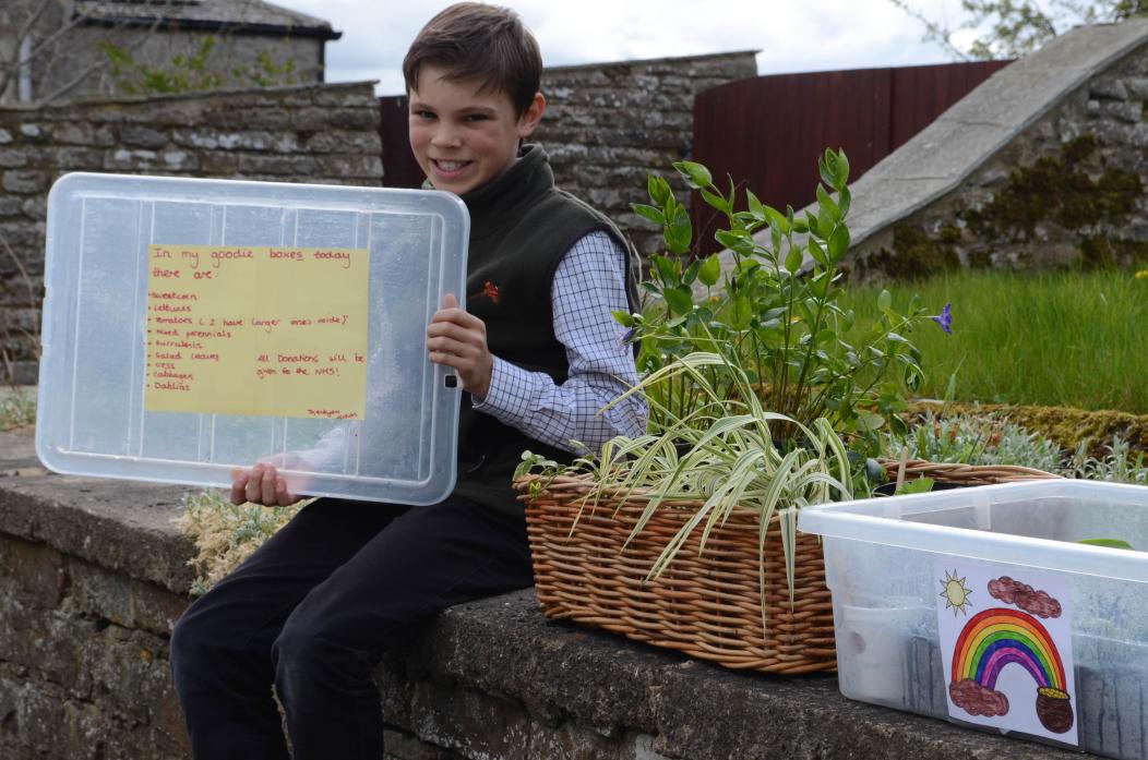 ENTERPRISING: Aidan Marmont with the stall outside his home. He is holding the list of items for sale
