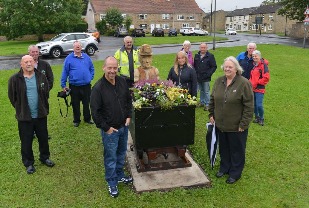 MINING HERITAGE: Auckland Gateway chairman Lee Brownson and West Auckland in Bloom volunteer Jean Pattison flank the new village green centrepiece while supporters look on