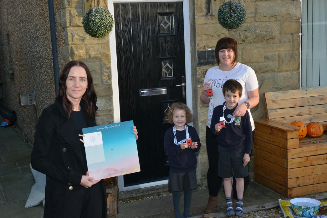 DIFFERENT APPROACH: Ali Collinson shows off one of the Make A Change vision boards while Tina Robson and her children Ryan and Lexie show off the medals they received for signing up to the British Legion’s My Poppy Run scheme as part of their own private