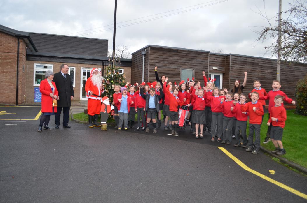 WINNERS: School staff and pupils jumping for joy after winning a Christmas Tree trail with their handcrafted decorations. They are pictured with Teesdale Lions’ very own Santa Claus, Bob Danby, and Sharon and Graham Walker    			    TM pic