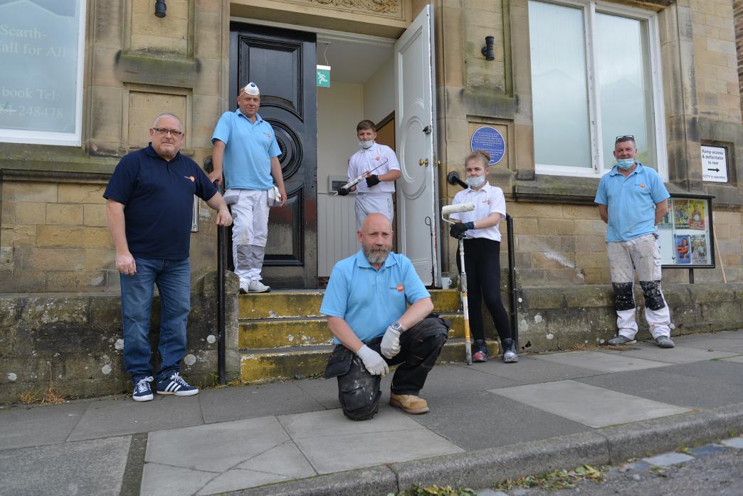 TEACHING SKILLS: Painting and decorating students Megan Cowan and Mason McMeekin (centre) received practical advice and help from qualified tradesmen Andrew Coxon, Charlie Wright, Nigel Stevens and Sean O’Brien while working at Scarth Memorial Hall last y
