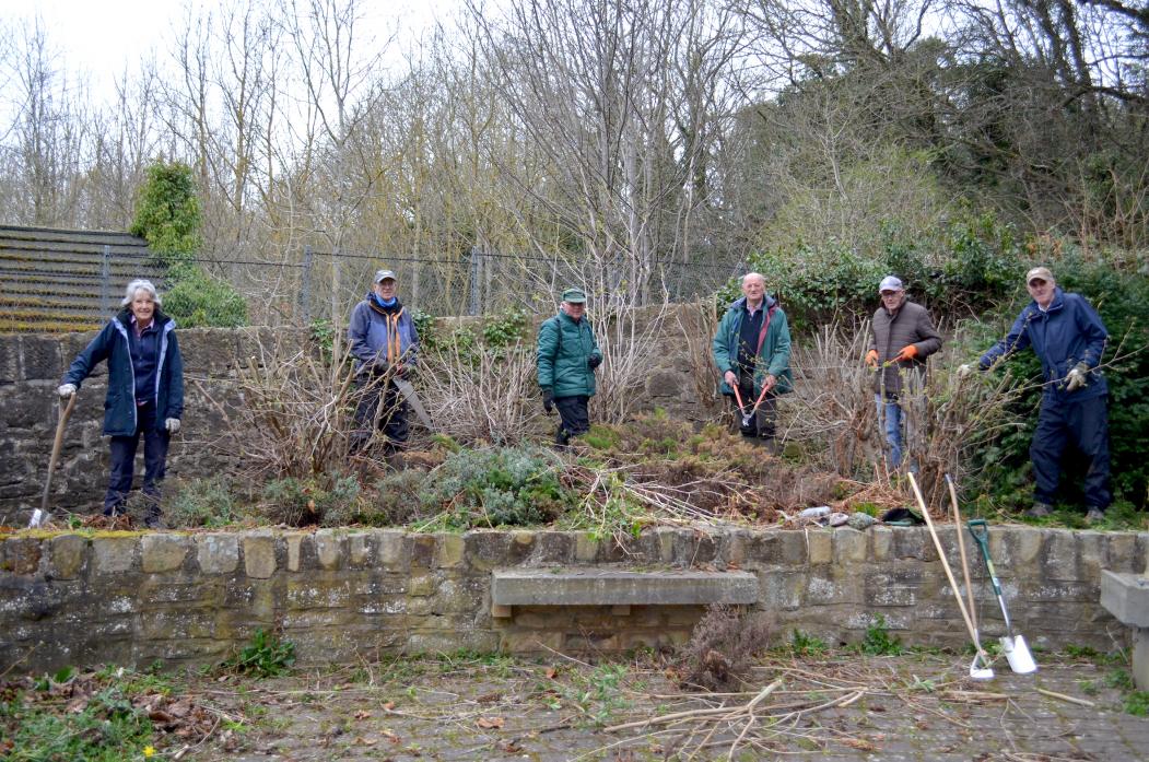 READY FOR ACTION: Barney’s volunteer workers get stuck into the overgrown undergrowth at the Roman Way picnic area. Right, Janet Sweeting cleans the information panel