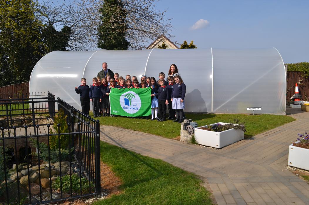 GOING GREEN: Pupils from year five with the newly awarded Green Flag for their eco-awareness, pictured with headteacher Chris Minikin and science lead Dr Felicity Greenwell