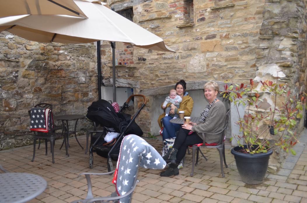 COSY AREA: Sue Jackson with daughter Ginny Teward and grandson Harry enjoyed sitting in what they say will become the worst kept secret in Barney, The Chocolate Fayre’s hidden garden area