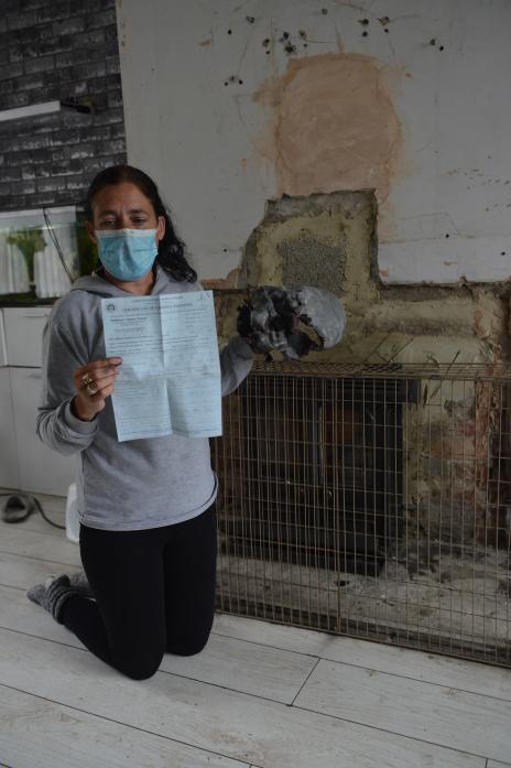 HEATING: Laura Henderson with the certificate which condemned the fireplace and heating system in her home more than a month ago