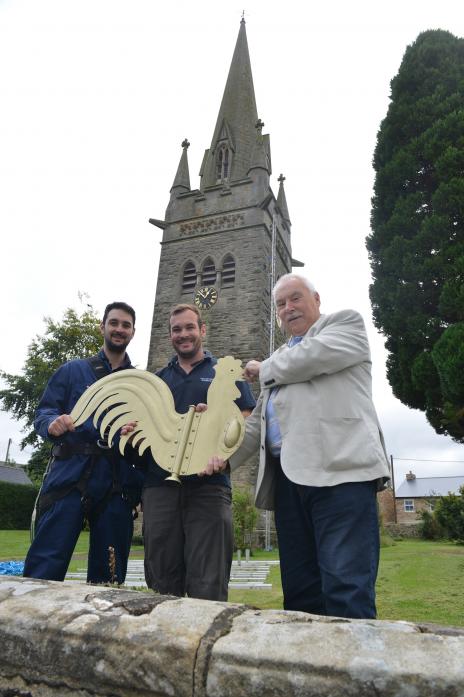 BACK UP: Drew Gibson and Sam Daltry, of Taylor Hastwell Steeplejacks, hold up the repaired weathervane cock along with assistant church warden Jeff Lynn ahead of putting it back after it was blown down in a storm