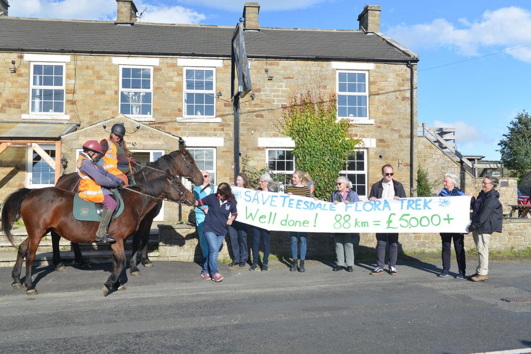 FLORA RIDE: A small crowd unfurled a banner to welcome Dr Margaret Bradshaw and Trisha Snaith as they completed their 88km Trek for Teesdale’s Flora