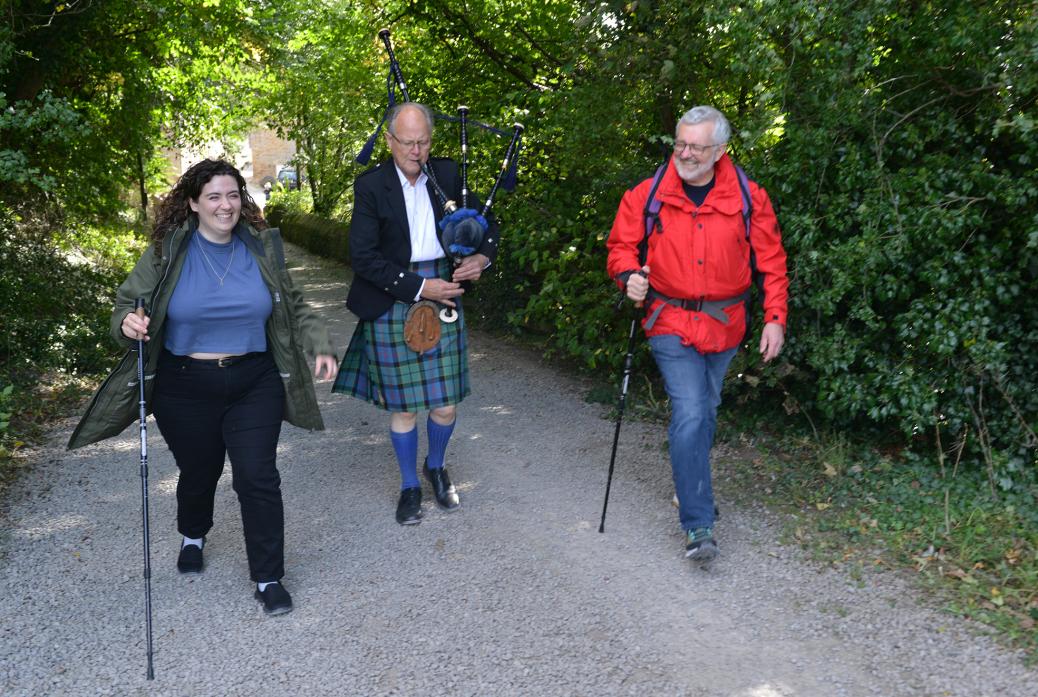 ON THEIR WAY: Sarah and Alan Morton are given a Scottish send-off by piper Angus Forsyth ahead of their nine-day hike across the West Highland Way  											    TM pic
