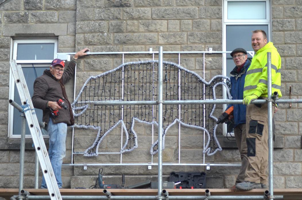 LIGHTING UP: Tim Raw, Roger Peat and Kevin Ness, of the Barnard Castle Christmas Lights group, put up the boar light motif on the Parish Hall. It marks the town's connection to Richard III