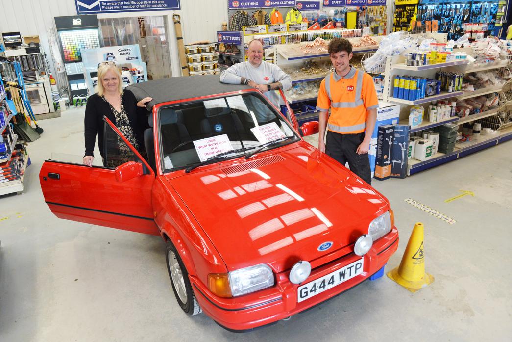 REVVED UP: Purchasing manager Alison Thackray, counter supervisor Steven McKie and yard operator Ryan Anderson with the classic 1990 Ford XR3i which was won by S&A Builders Merchants and will be sold for charity                      TM pic