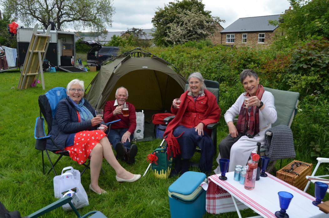 PARTY TIME: Lilian and David Smith came prepared for all weathers when they enjoyed the alfresco party with Carol Lynn and Judith Walker-Hutchinson TM pic