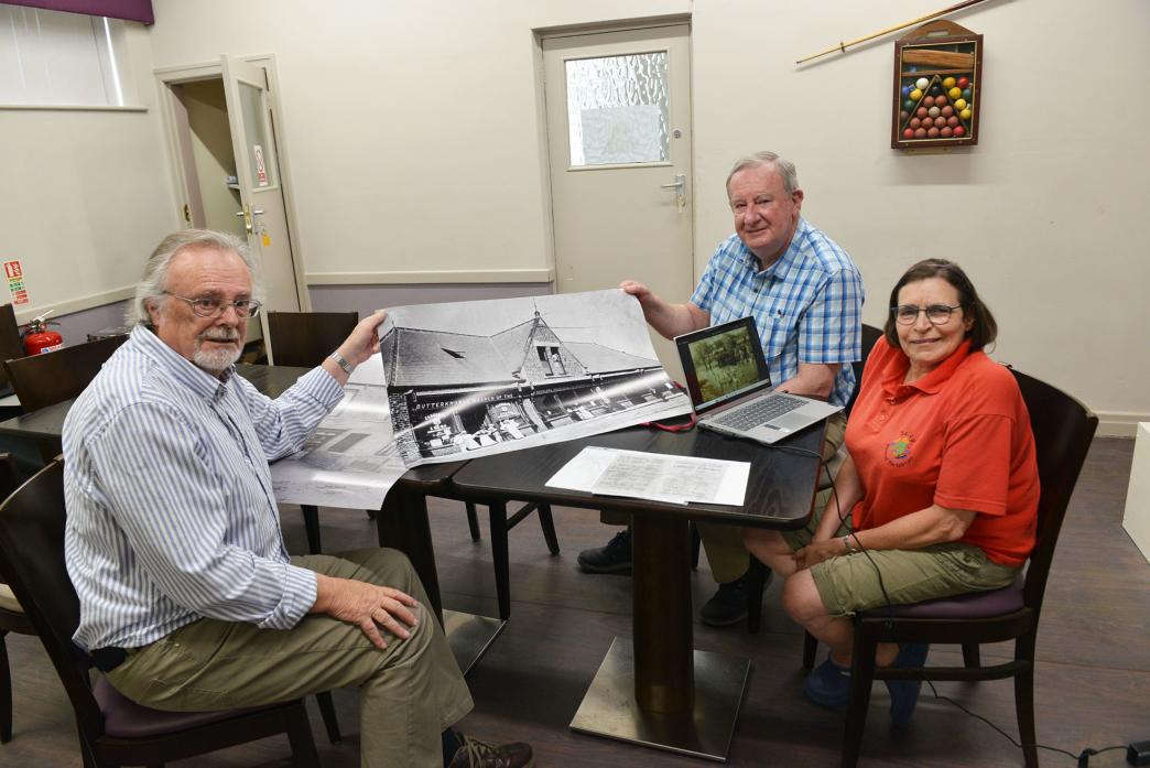 GONE BUT NOT FORGOTTEN: History group members David Wallace, Fred Atkins and Jeanette Newell examine some of the photographs and memorabilia that will be on display, including a large picture of the huge Co-op store that once existed in Butterknowle. It h