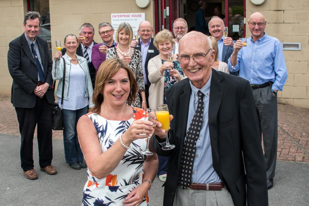CHEERS! Alastair Dinwiddie and Lynn Todhunter raise a glass to 20 years of Enterprise House. Behind are a few of the many guests at the celebration event