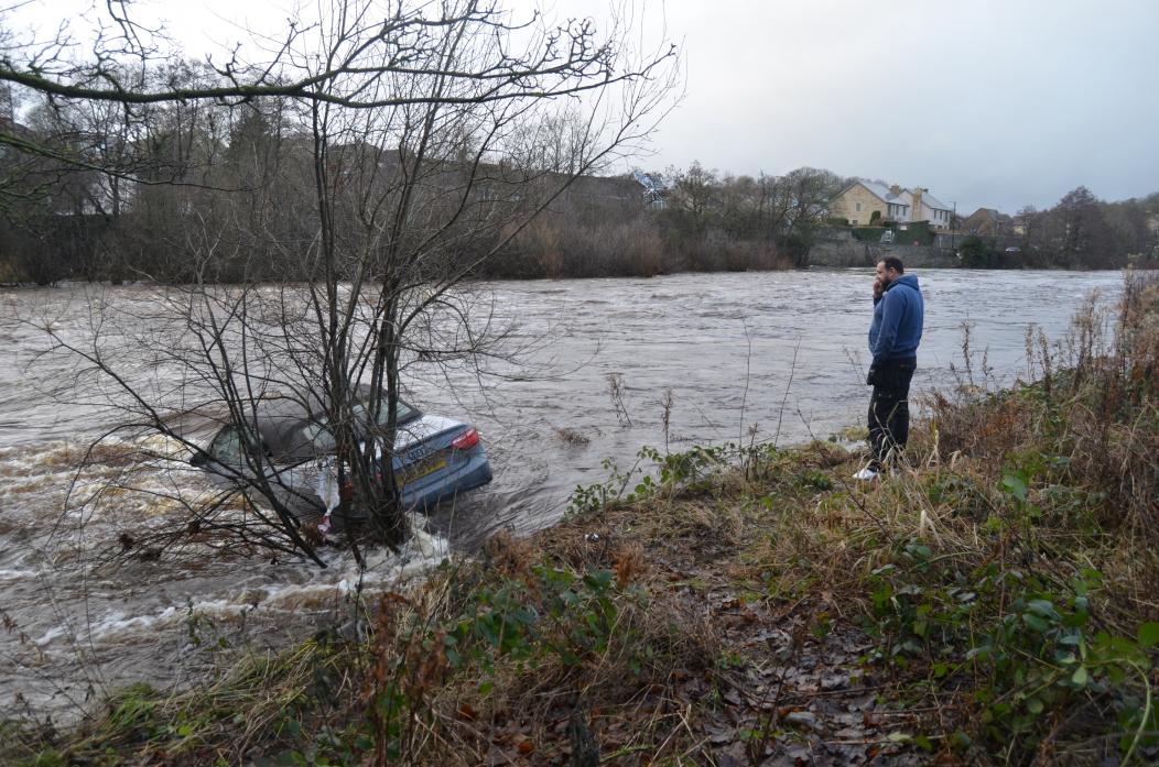 OH NO: Car owner Calvin Saville looks on at his submerged vehicle which took a new year dip in the River Tees