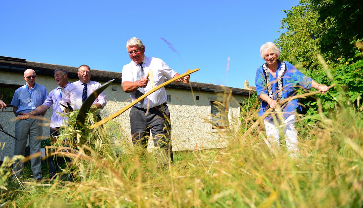 LONG GRASS: Police and Crime Commissioner Ron Hogg and mayor Cllr Sandra Moorhouse see the funny side by trying their hand at scything the long grass at Bede Kirk. However, amusement turned to shock soon after when police revealed how much they were expec